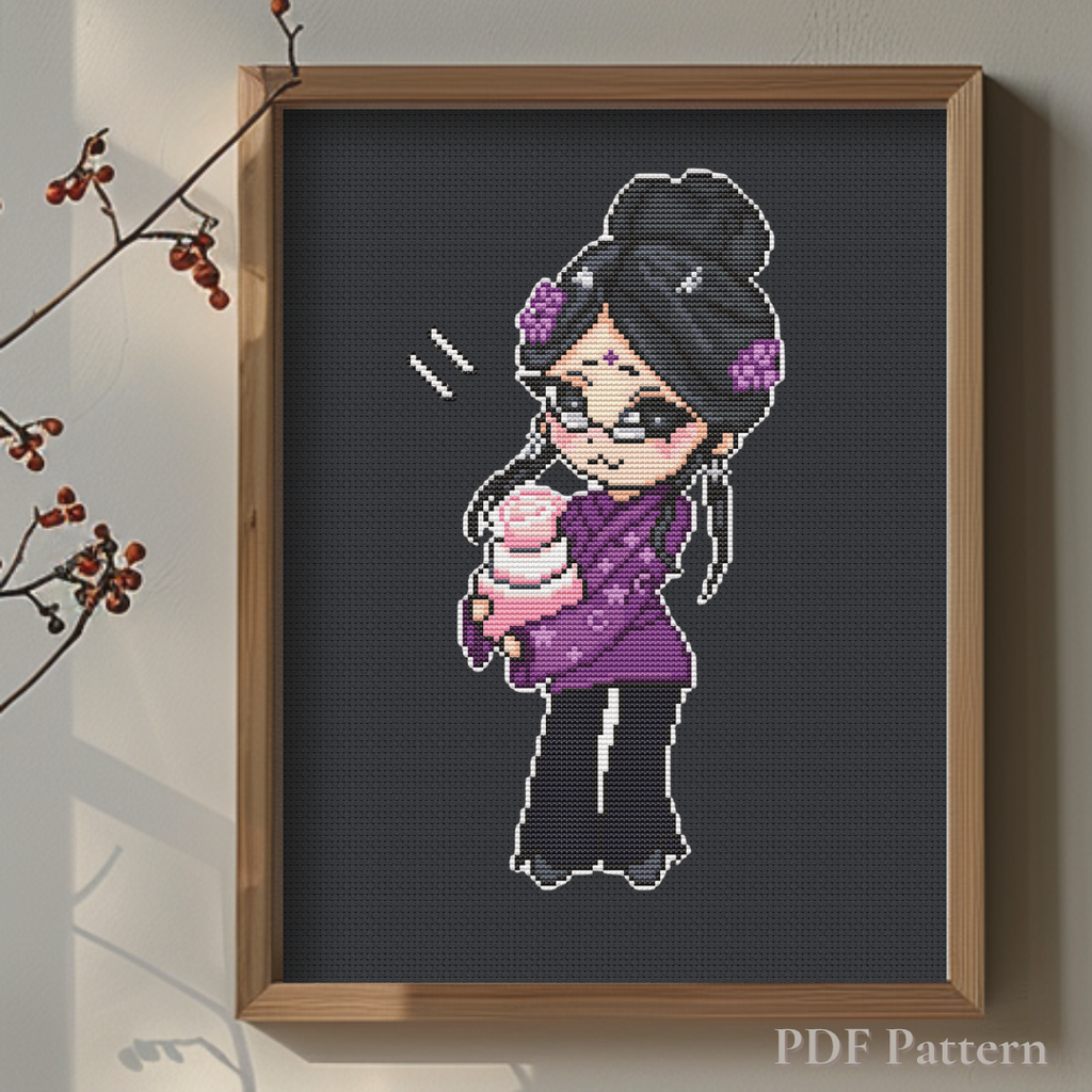 Aunt Karma cross stitch pattern displayed in a wooden frame on black fabric, highlighting the vibrant purple outfit and pink birthday cake in a warm minimalist interior.