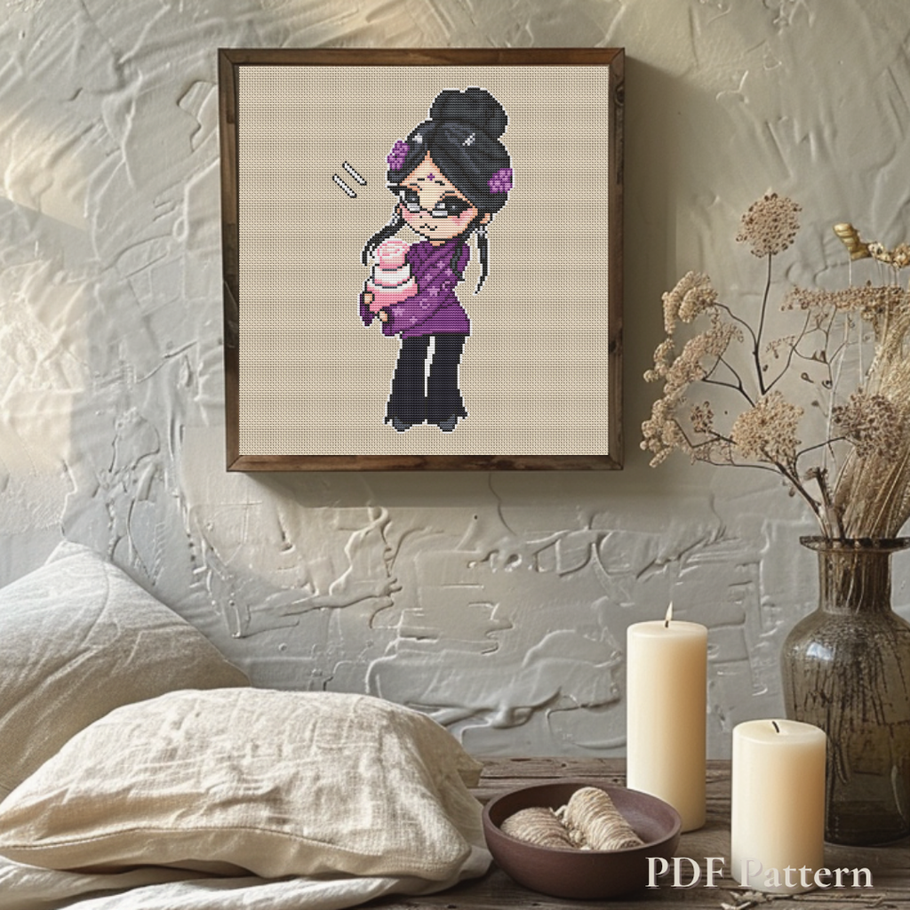 Framed Aunt Karma cross stitch displayed in a cozy neutral bedroom with candles, dried flowers, and textured walls, showcasing the finished embroidery as cottage-style home decor.