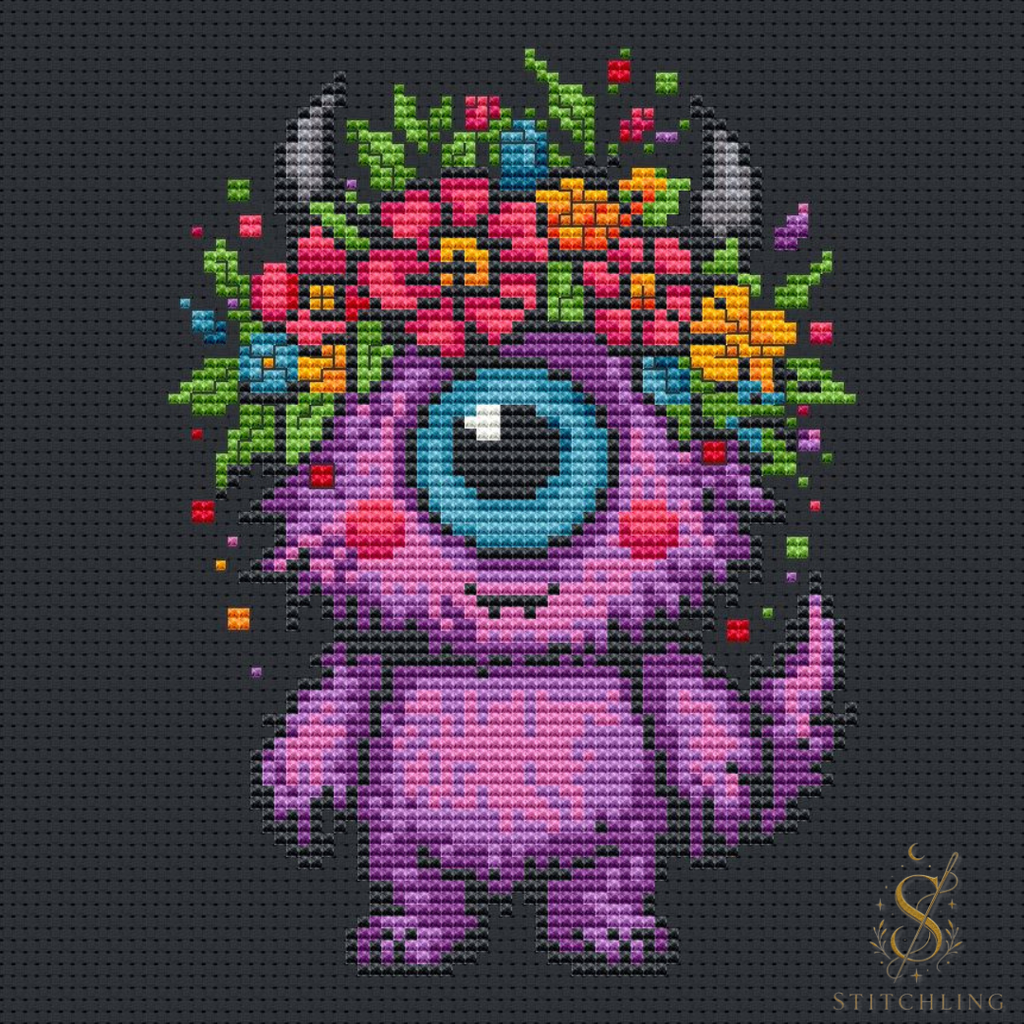 Bloom the Dreaming Beast cross stitch pattern featuring a one eyed fantasy creature with colorful flowers, whimsical embroidery design on a dark background