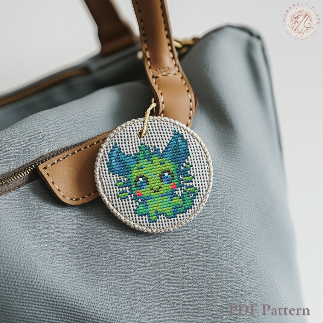 Cute Lumi Beastie embroidered charm attached to a handbag, stitched from the Lumi Mini Set pattern.